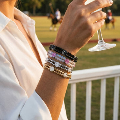 NOGU Smile Bracelet Collection stacked beaded bracelets with black, pink, white and gold smiley charms.