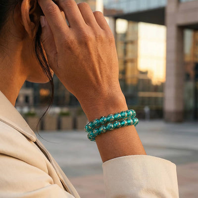 NOGU Teal Firefly Glass bracelet with luminous teal glass beads, styled as a double-wrap strand on the wrist.