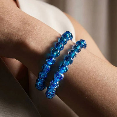 NOGU Hand Blown Lampwork Glass bracelets with glowing cobalt blue beads and shimmering flecks, styled on the wrist.