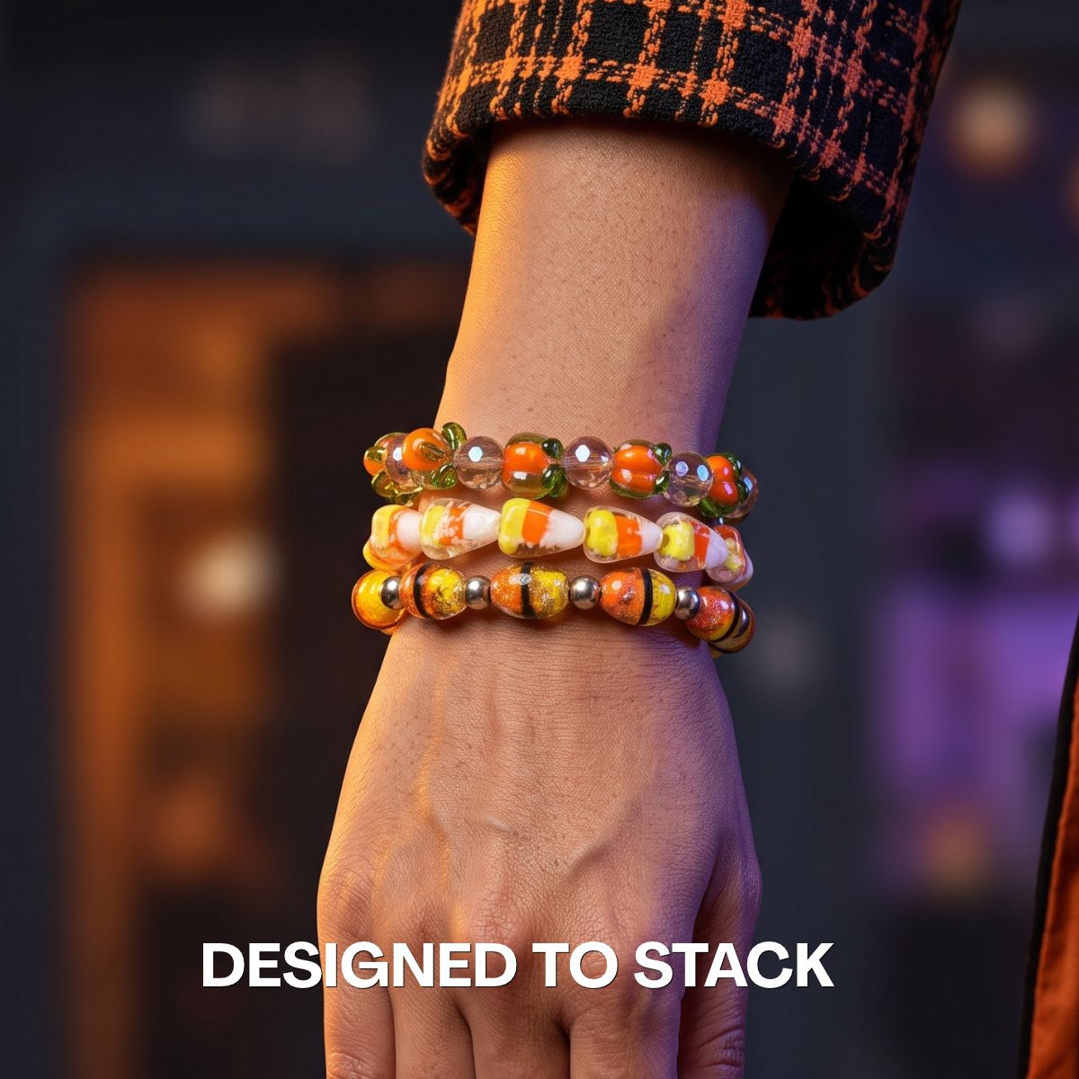 Stacked colorful beaded bracelets in orange, yellow, green and white glass beads styled on a wrist.