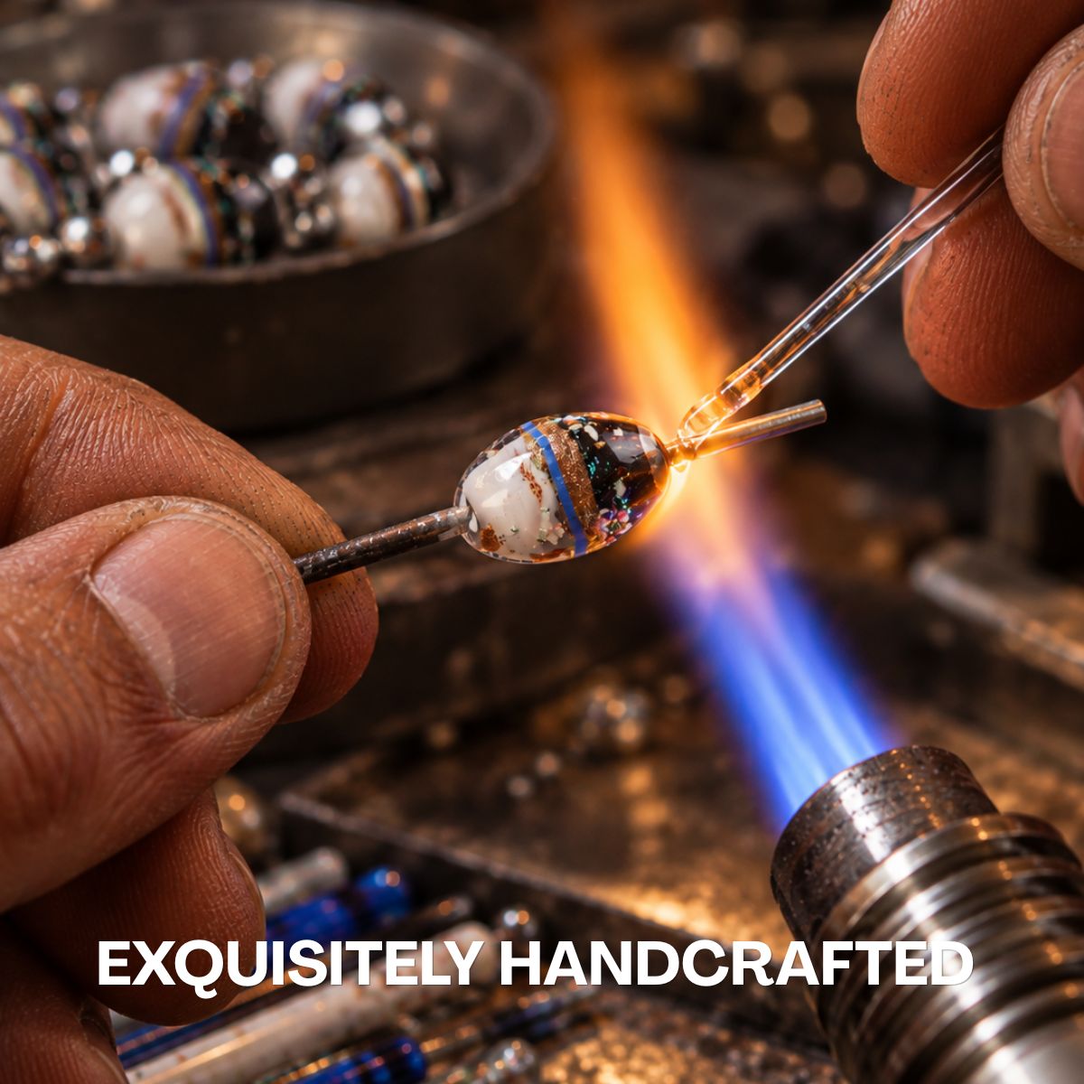 Artisan handcrafts a clear glass bead with white, blue and copper-toned details over an open flame.