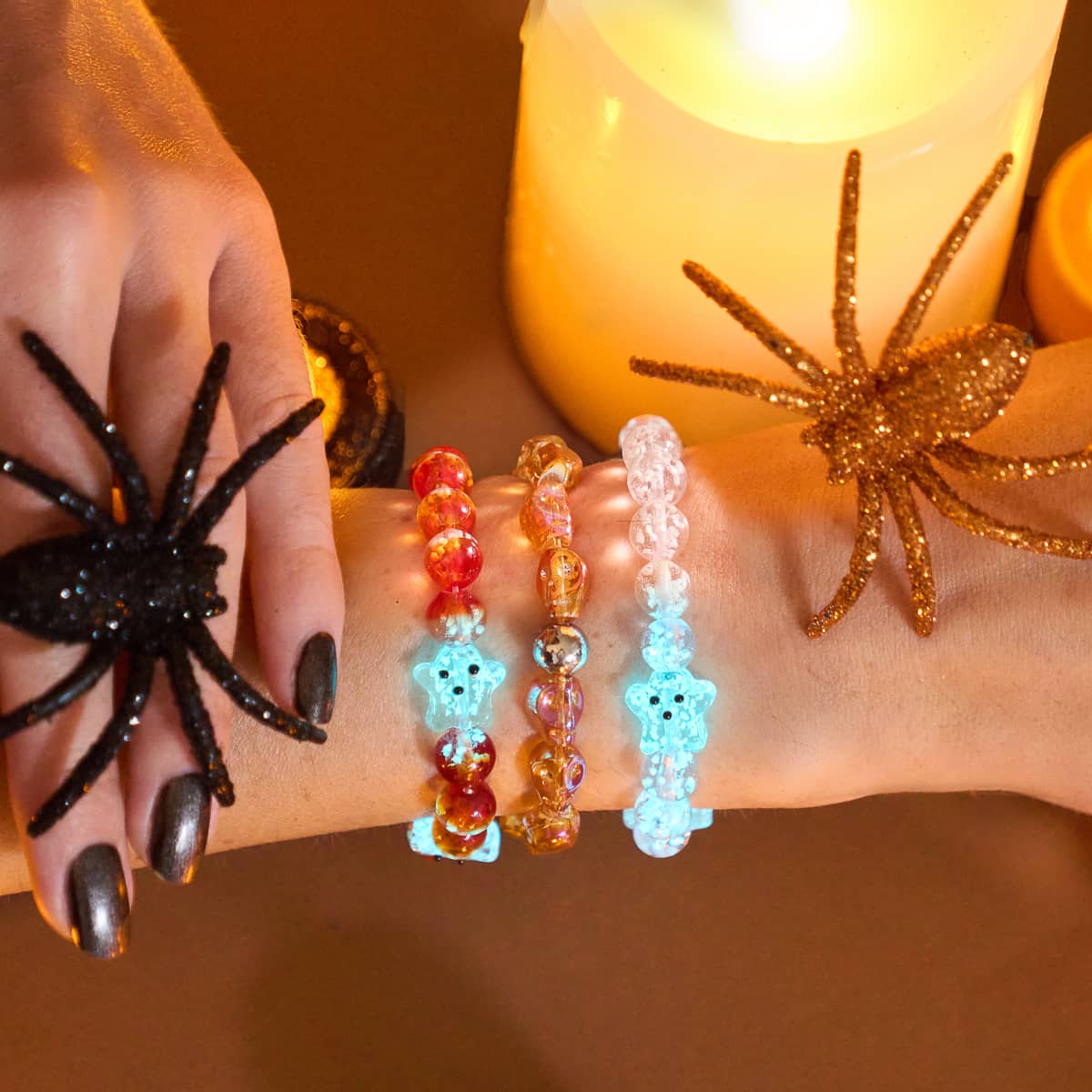 腕には、Berry Boo Silver Firefly Glass Ghostの3つのブレスレットがあり、青く光るゴーストビーズとオレンジ色のランプワークビーズがNOGU