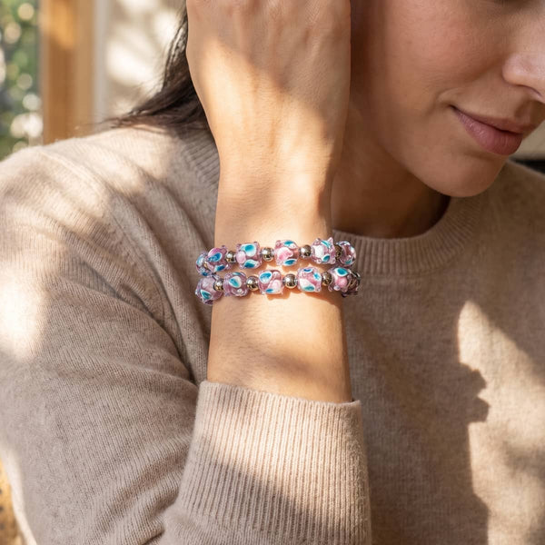 Model wearing a double-strand Firefly glass tulip bracelet with pink and turquoise floral beads and silver-tone accents.