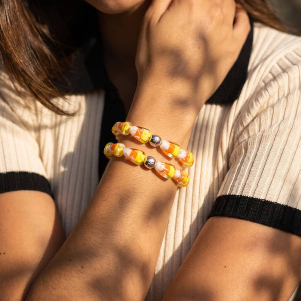 NOGU candy corn Firefly Glass bracelet with orange, yellow and white lampwork beads and silver stainless steel accents.