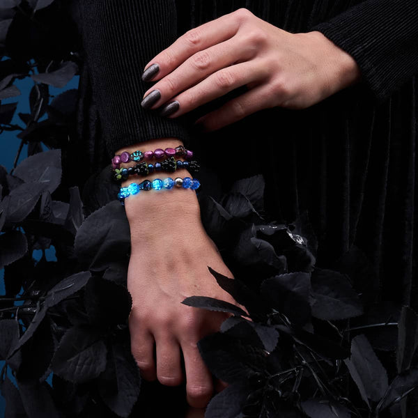 Eerie Tides glow-in-the-dark Firefly Glass skull bracelet in blue with two additional bracelets on wrist by NOGU